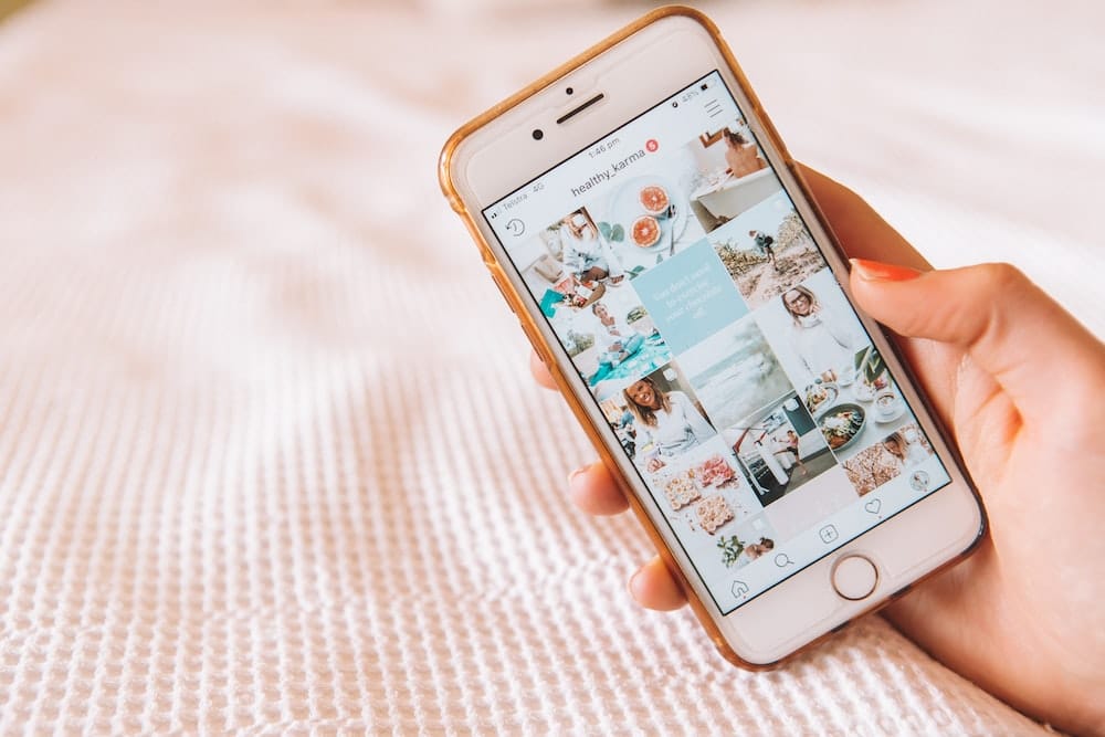 Instagram profile on phone screen, symbolizing influencer marketing to boost content visibility